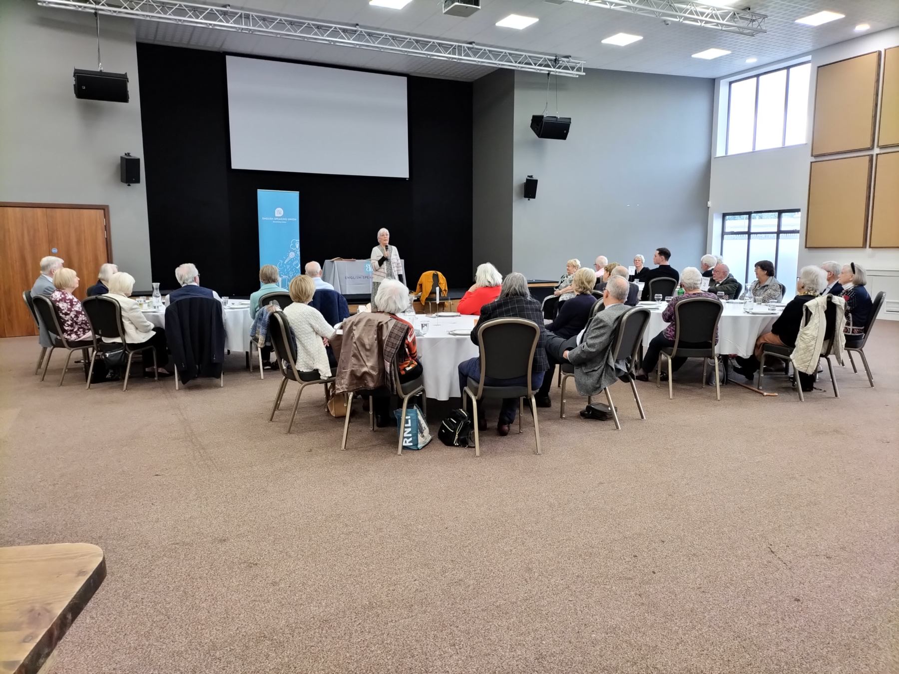 A group of people listening to a speaker at an event
